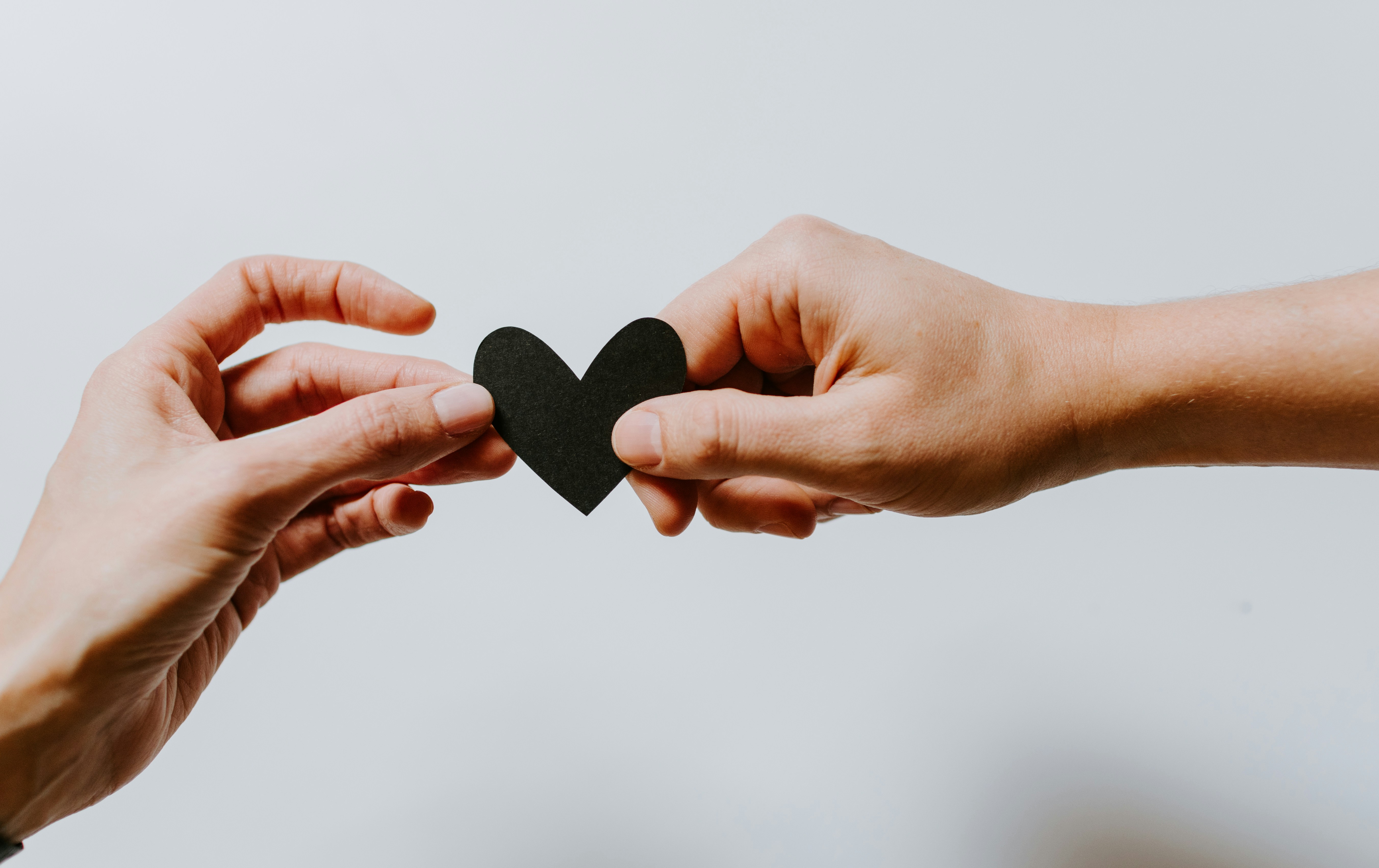 Two hands sharing a heart